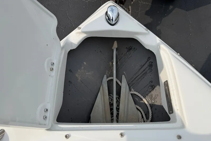 Slide: The Image of Anchor storage compartment on a 2011 Crownline 21 SS boat, featuring anchor and rope. - 7