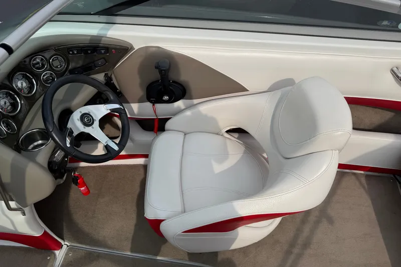 Slide: The Image of Interior of a 2011 Crownline 21 SS boat featuring steering wheel and dashboard controls. - 9