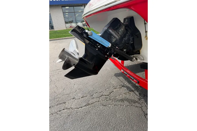 Slide: The Image of 2011 Crownline 21 SS boat with MerCruiser outdrive, red hull, parked on pavement. - 17