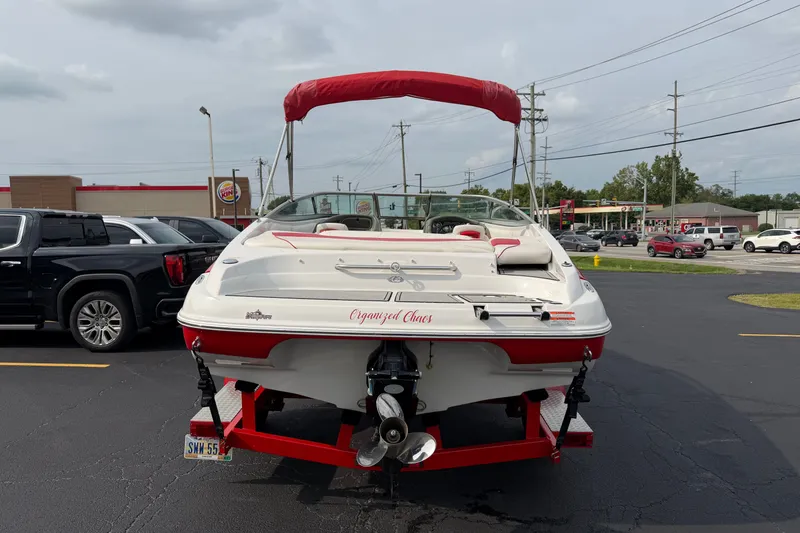 Slide: The Image of 2011 Crownline 21 SS boat with red canopy on trailer in parking lot. - 15
