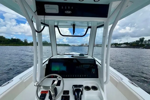 Slide: The Image of 2022 Sea Hunt Ultra 265SE boat dashboard with steering wheel, controls, and water view. - 6