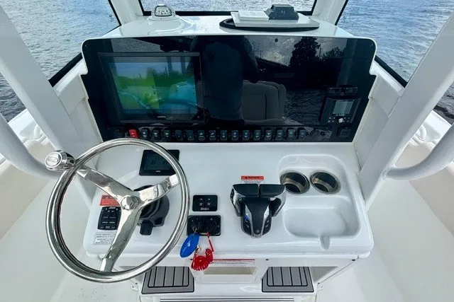 Slide: The Image of 2022 Sea Hunt Ultra 265SE helm with steering wheel, controls, and navigation display. - 5