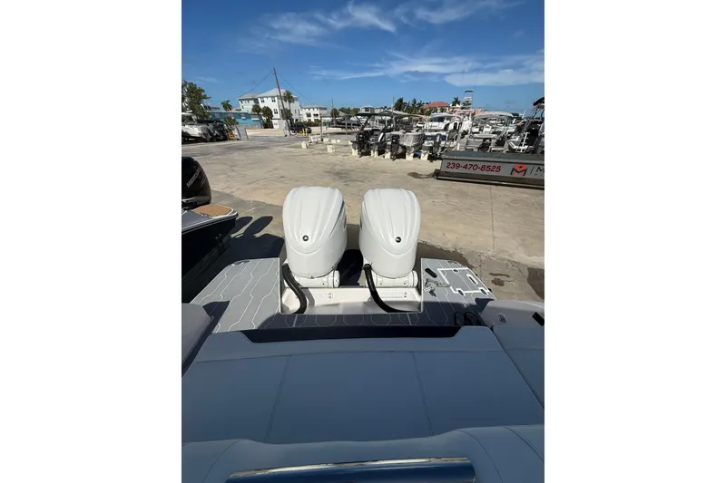 Slide: The Image of 2022 Regal 33 OBX boat with dual outboard engines at a marina. - 4