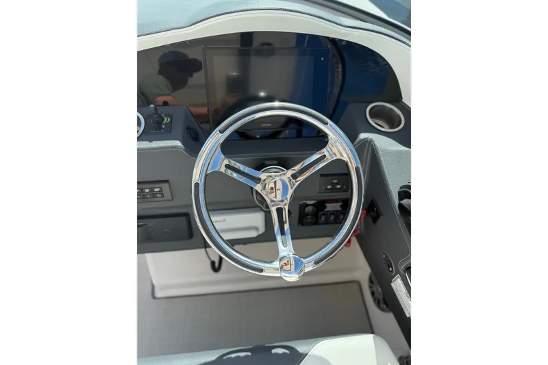 Slide: The Image of Steering wheel of 2022 Regal 33 OBX boat, featuring modern dashboard controls. - 17
