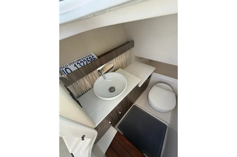 Slide: The Image of 2022 Regal 33 OBX boat bathroom with sink, toilet, and storage. - 26
