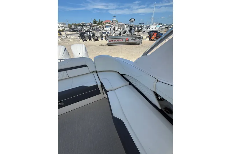 Slide: The Image of 2022 Regal 33 OBX boat interior with white seating at a marina. - 16