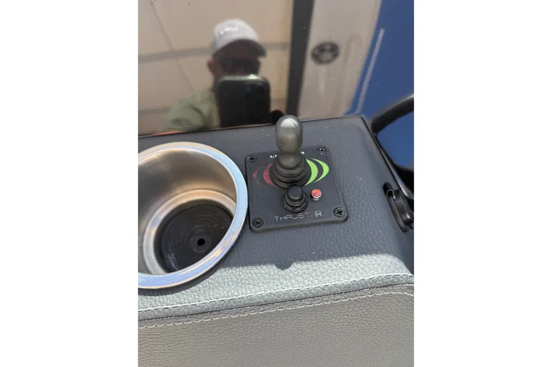 Slide: The Image of Control panel of a 2022 Regal 33 OBX boat with joystick and cup holder. - 23