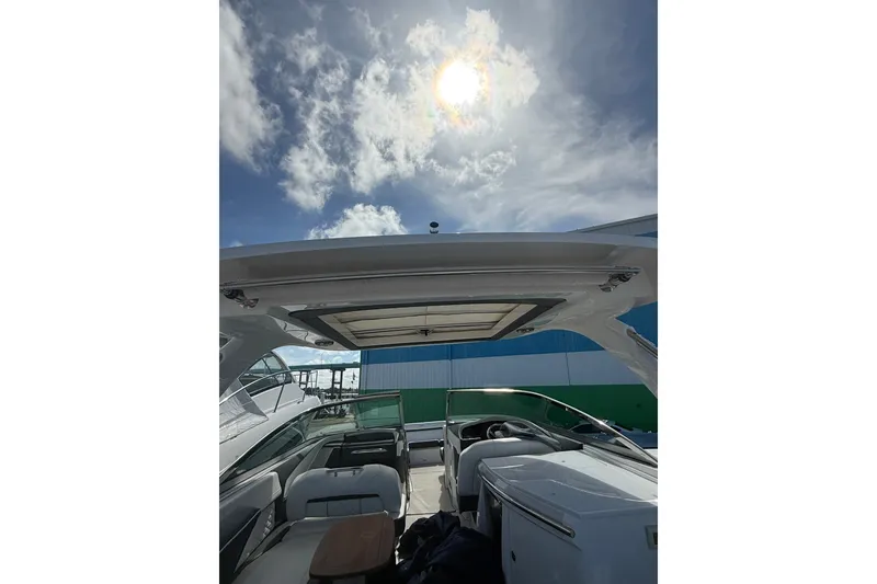 Slide: The Image of 2022 Regal 33 OBX boat interior under sunny sky with clouds. - 7