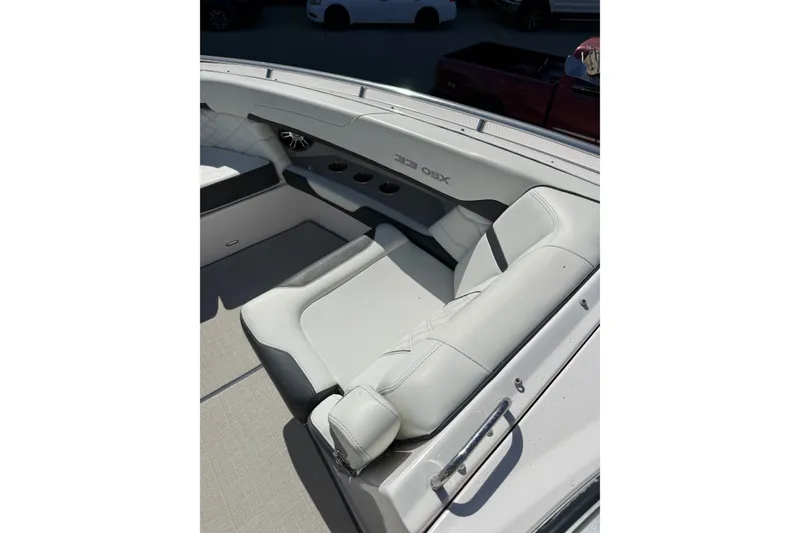Slide: The Image of 2022 Regal 33 OBX boat interior with white seating and cup holders. - 33