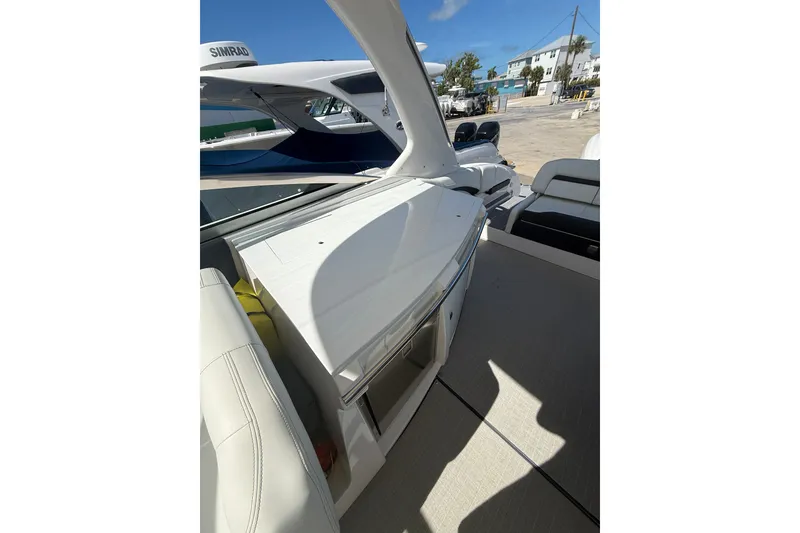 Slide: The Image of 2022 Regal 33 OBX boat interior with seating and storage, docked under clear blue sky. - 12