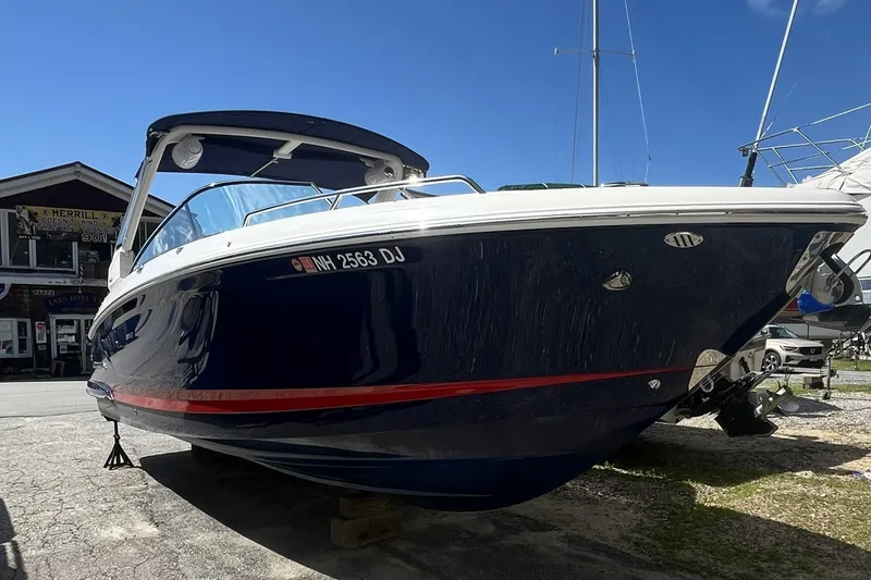 Slide: The Image of 2020 Chaparral 297 SSX boat on display, blue hull, sunny day, outdoor setting. - 1