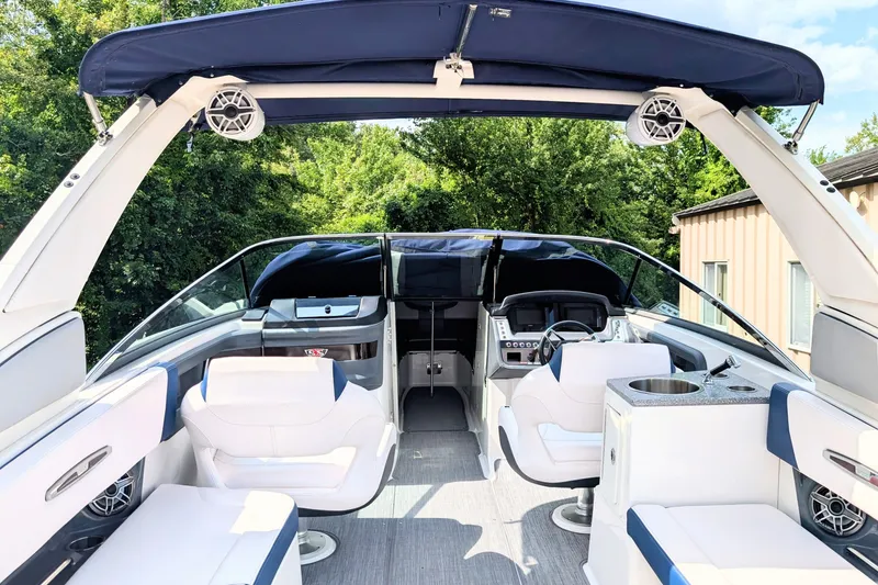 Slide: The Image of 2020 Chaparral 297 SSX boat interior with seating and helm, featuring a blue canopy. - 11