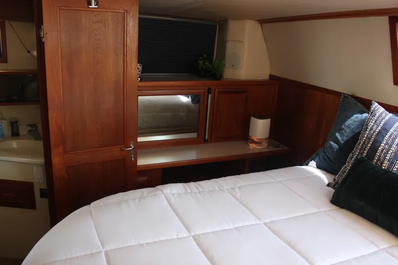 Slide: The Image of Cozy cabin interior of 1989 Californian 55 Cockpit Motor Yacht with wooden accents and plush bedding. - 31