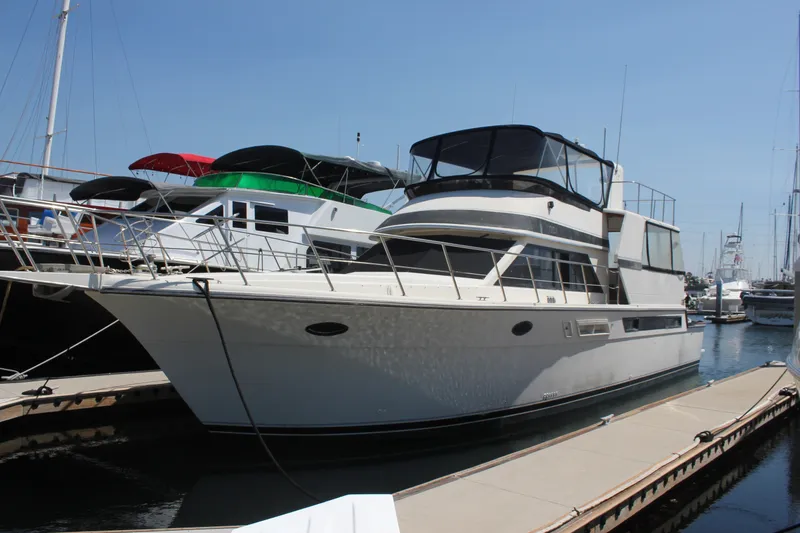 The Image of 1989 Californian 55 Cockpit Motor Yacht docked at marina under clear blue sky. - 1