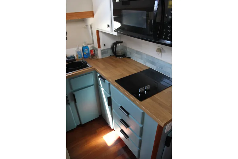 Slide: The Image of Compact kitchen in 1989 Californian 55 Cockpit Motor Yacht with modern appliances. - 15
