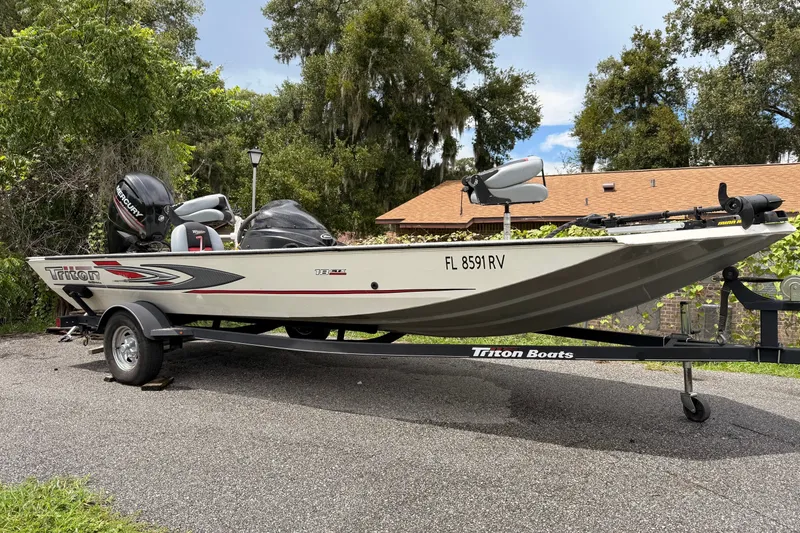 The Image of 2017 Triton 18 C TX boat on trailer, parked outdoors. - 0