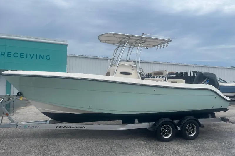 Slide: The Image of 2023 Cobia 237 Center Console boat on trailer, parked outdoors. - 4