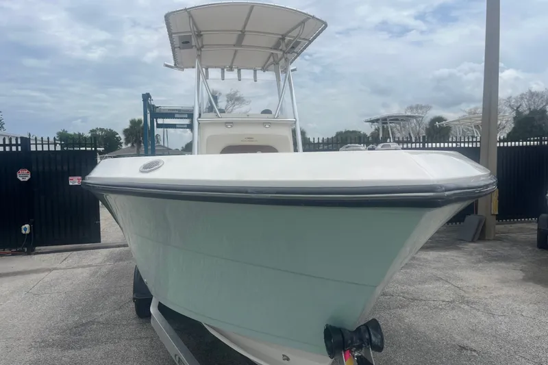 Slide: The Image of 2023 Cobia 237 Center Console boat on trailer, parked outdoors. - 2