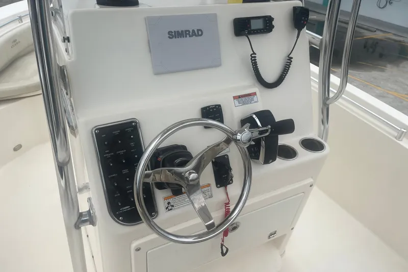 Slide: The Image of 2023 Cobia 237 Center Console boat helm with steering wheel and controls. - 8