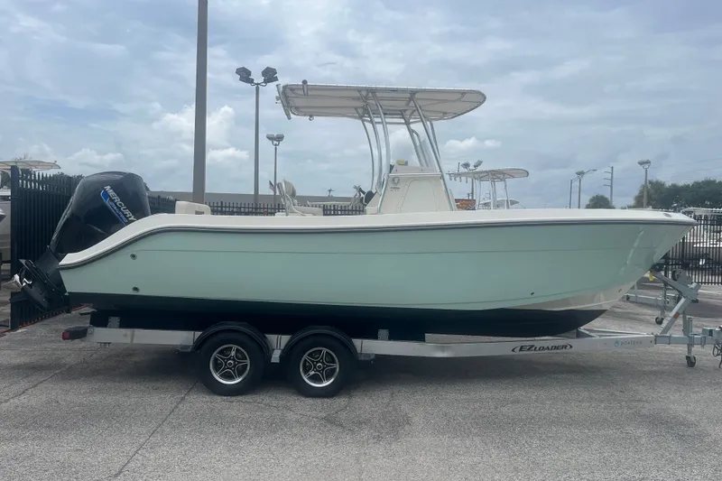 The Image of 2023 Cobia 237 Center Console boat on trailer, side view. - 0