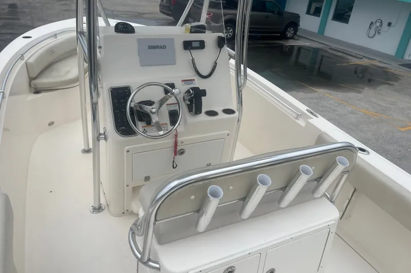 Slide: The Image of 2023 Cobia 237 Center Console boat interior with steering wheel and rod holders. - 10