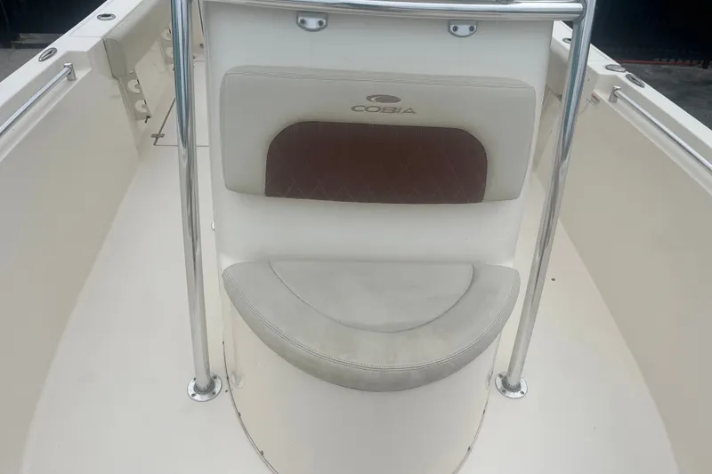 Slide: The Image of 2023 Cobia 237 Center Console boat seating area with cushioned backrest and stainless steel rails. - 7