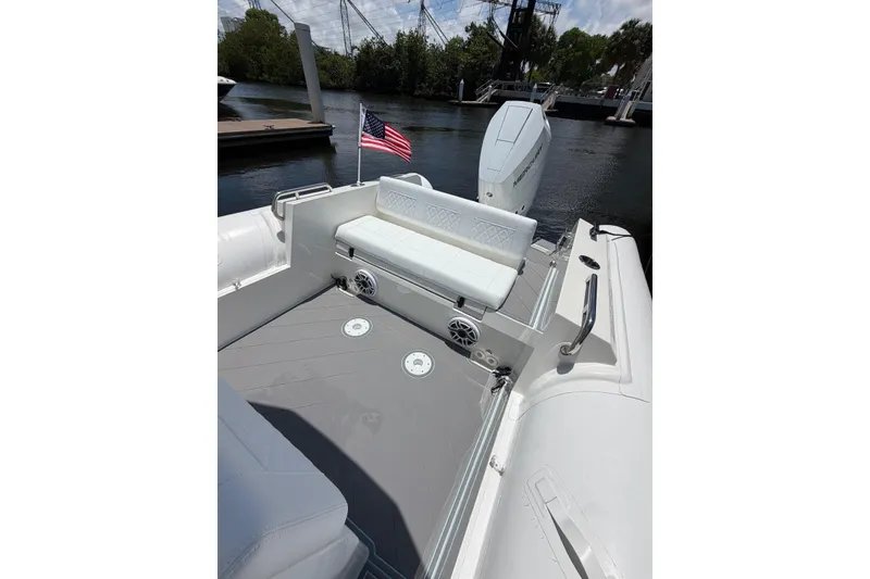 Slide: The Image of 2023 Northstar Orion 8 boat interior with seating, American flag, and water backdrop. - 14