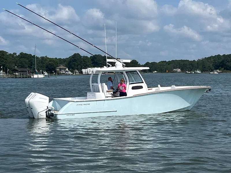 Slide: The Image of A 2026 Phenom 34 boat on calm water with two people aboard and two fishing rods. - 5