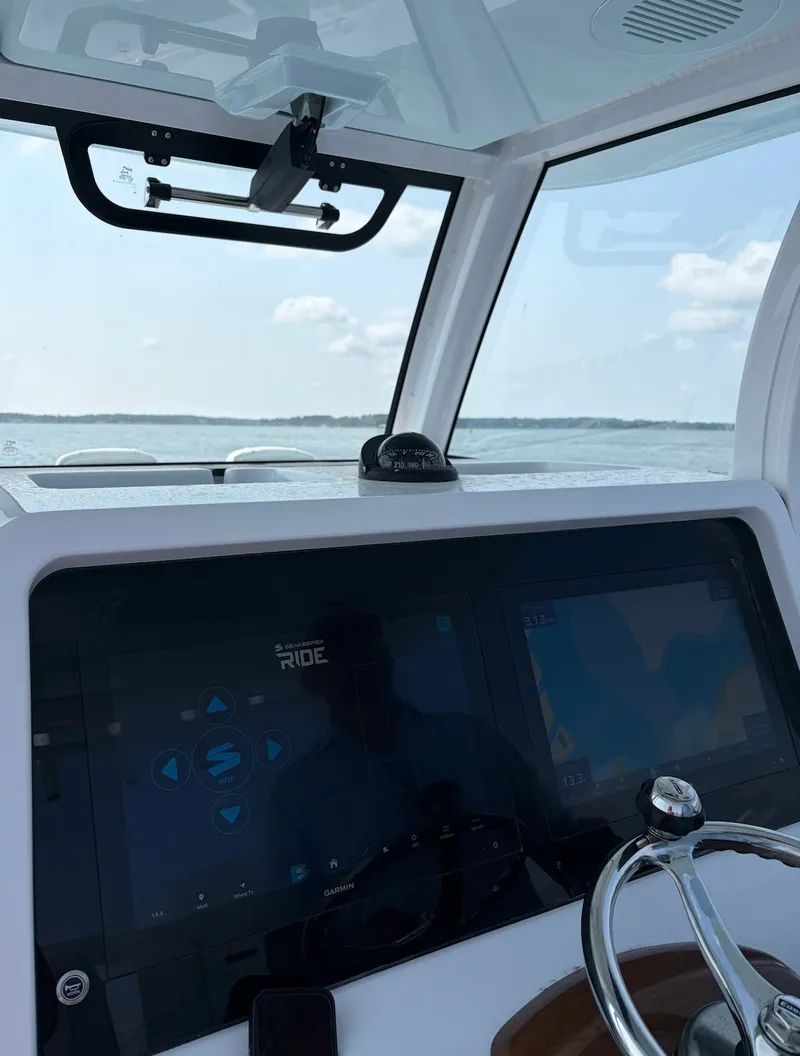 Slide: The Image of The cockpit of the Phenom 34 features modern navigation screens and a sleek steering wheel against a water backdrop. - 32