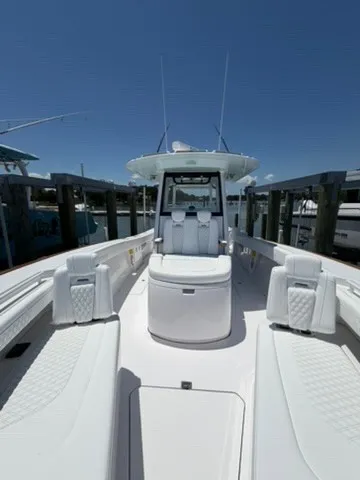 Slide: The Image of The image shows a modern boat docked, featuring a spacious deck and white upholstery. - 12