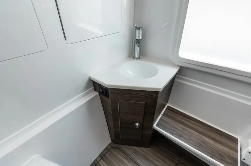 Slide: The Image of The image shows a modern boat bathroom with a sink and wood paneling. - 28