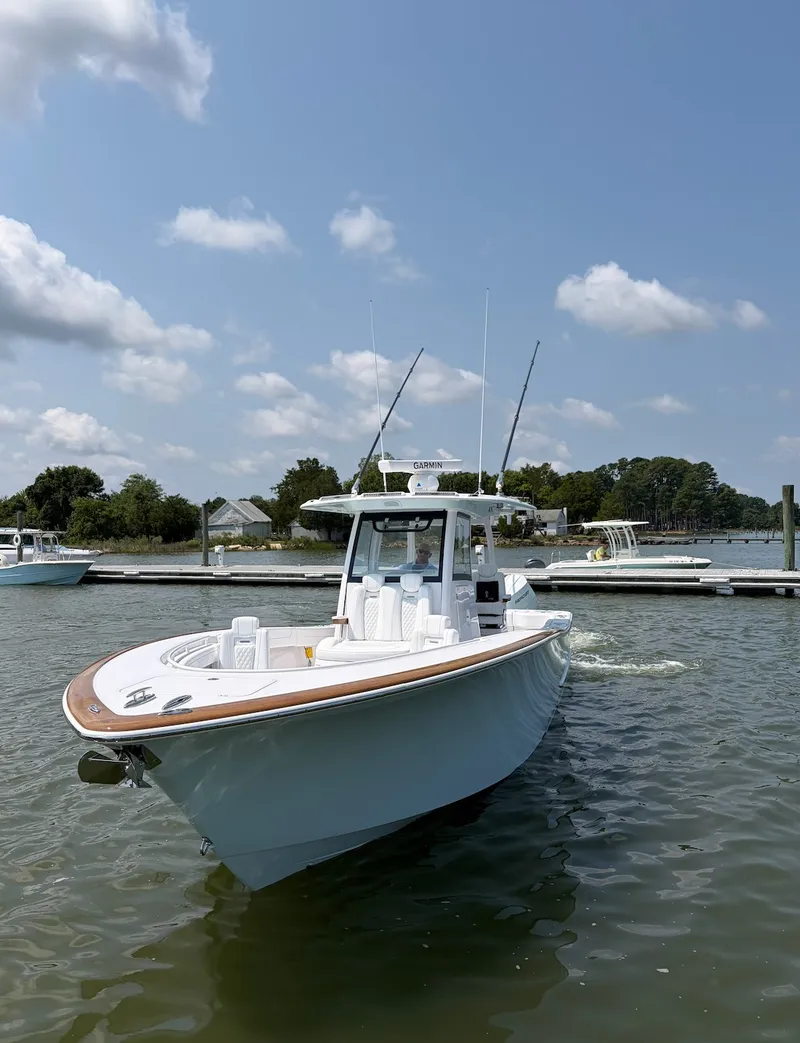 Slide: The Image of A modern 2026 Phenom 34 boat on calm waters. The sky is partly cloudy. - 7