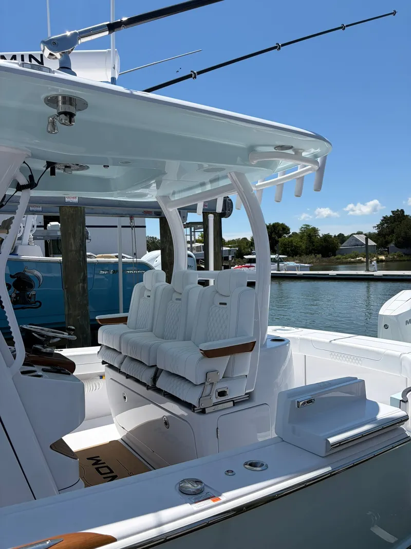 Slide: The Image of The image shows a modern boat with white upholstery and sleek design docked at a marina. - 18