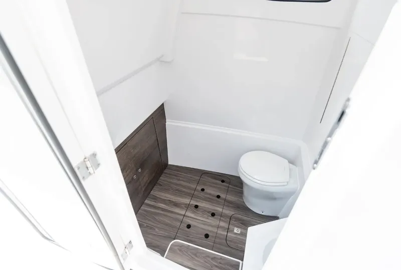 Slide: The Image of The image shows a modern boat bathroom with a wooden floor and a toilet. - 29