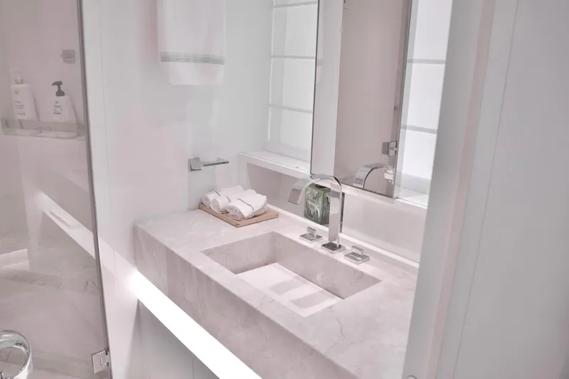 Slide: The Image of An elegant bathroom with a modern sink, towels, and a mirror. - 28