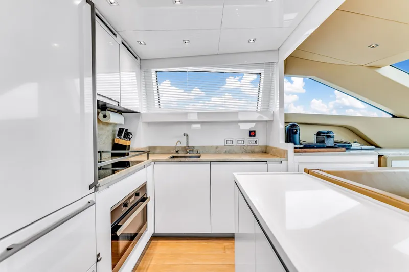 Slide: The Image of Modern kitchen interior on 2018 Sanlorenzo SL78 yacht, featuring sleek white cabinetry and appliances. - 12
