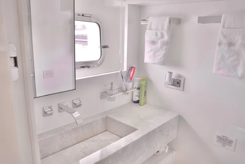 Slide: The Image of A sleek bathroom with a modern sink, towels, and a small window. - 22