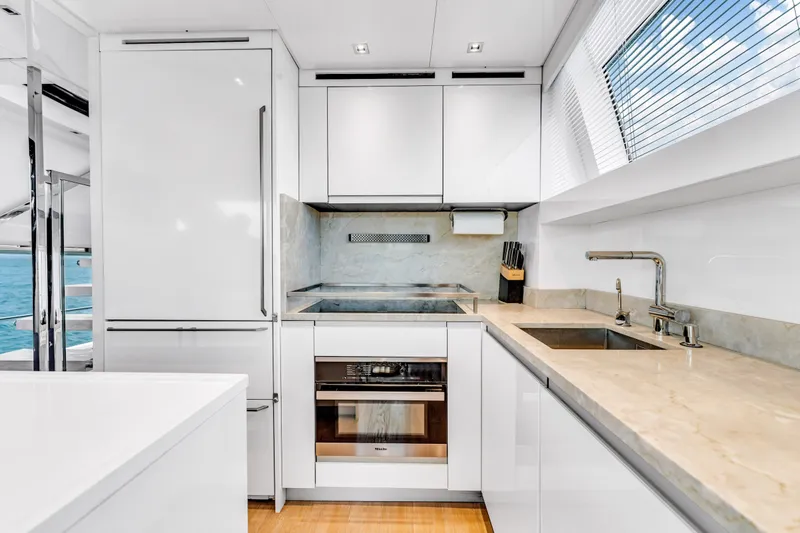 Slide: The Image of Modern kitchen interior on 2018 Sanlorenzo SL78 yacht, featuring sleek white cabinetry and ocean view. - 11