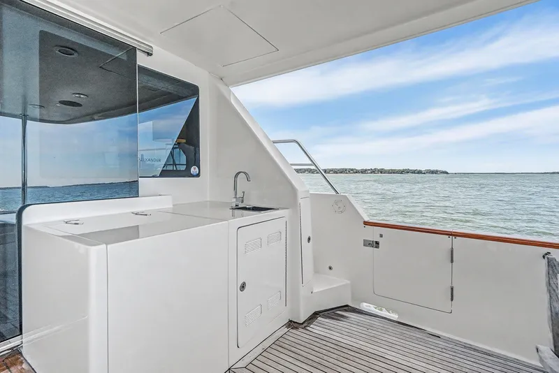 Slide: The Image of 2013 Ocean Alexander 65 Pilothouse yacht deck with sink, overlooking serene waters. - 8