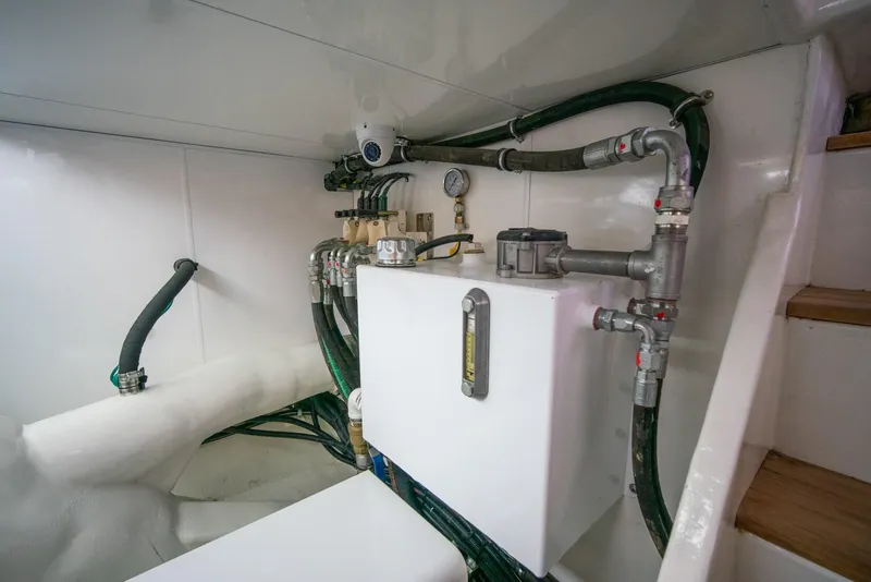 Slide: The Image of The engine room of a 2013 Ocean Alexander 65 Pilothouse features pipes and valves. - 52