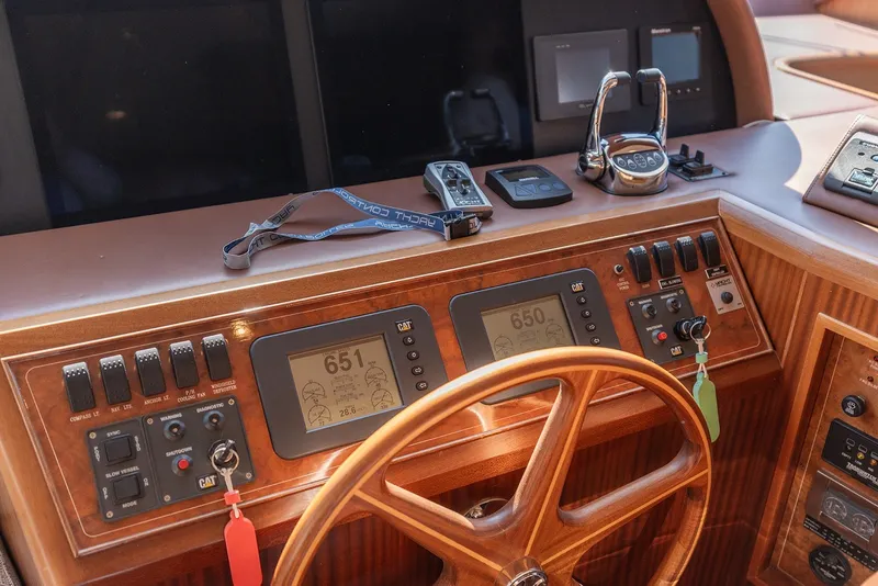 Slide: The Image of Pilothouse of 2013 Ocean Alexander 65, featuring navigation controls and wooden steering wheel. - 20