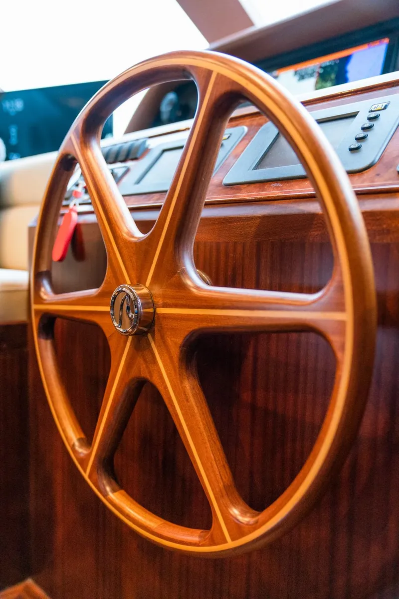 Slide: The Image of A sleek wooden steering wheel on the 2013 Ocean Alexander 65 Pilothouse. - 23