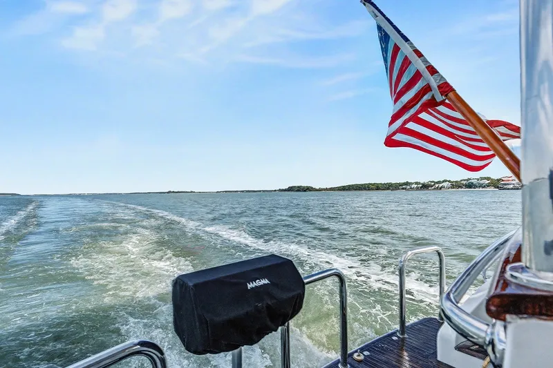 Slide: The Image of Ocean Alexander 65 Pilothouse 2013 cruising with American flag, scenic water view. - 7