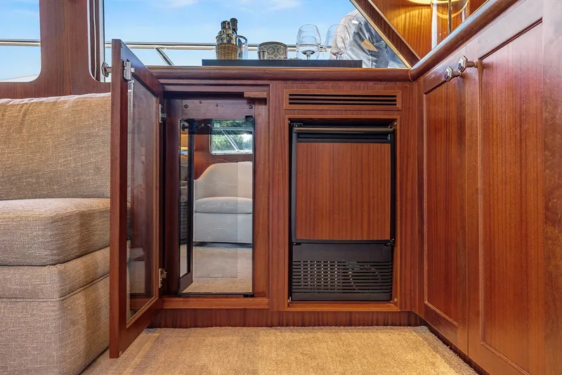 Slide: The Image of Luxurious interior of 2013 Ocean Alexander 65 Pilothouse yacht with wooden cabinetry and mini fridge. - 13
