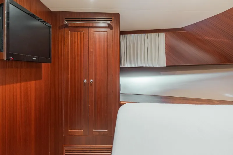 Slide: The Image of Luxurious cabin interior of 2013 Ocean Alexander 65 Pilothouse yacht with TV and wooden cabinetry. - 34