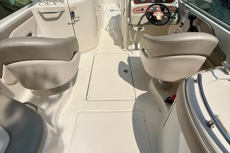 Slide: The Image of Interior view of a 2005 Sea Ray 270 Sundeck boat, featuring seating and steering area. - 21