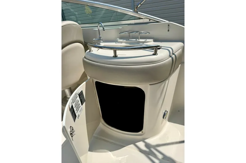 Slide: The Image of 2005 Sea Ray 270 Sundeck interior with open storage compartment and seating. - 19