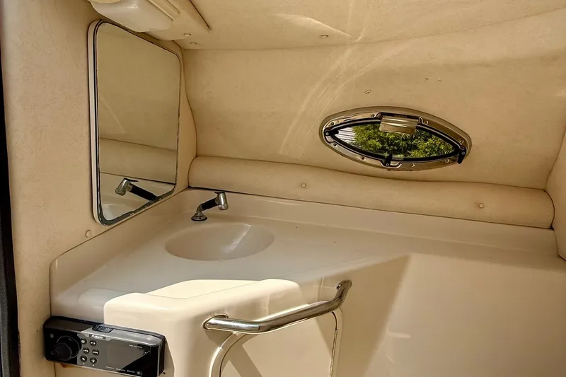Slide: The Image of Interior of 2005 Sea Ray 270 Sundeck boat with sink, mirror, and porthole window. - 10
