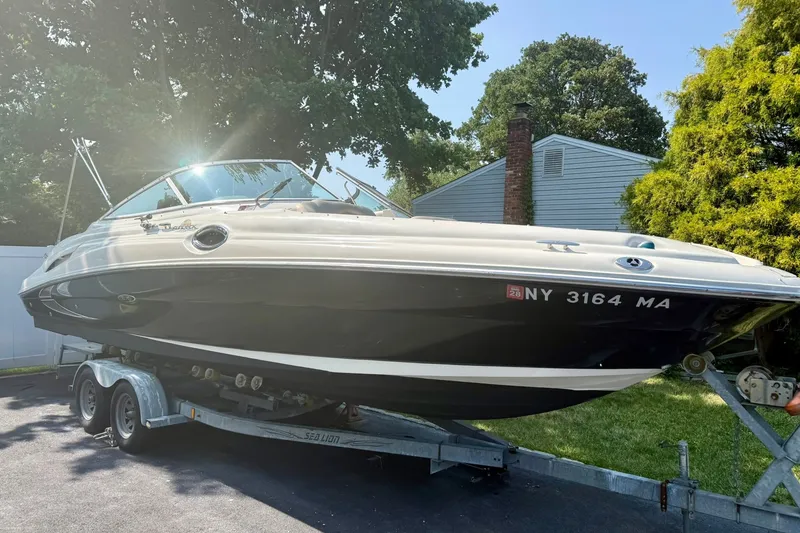 Slide: The Image of 2005 Sea Ray 270 Sundeck boat on trailer, parked outdoors in a residential area. - 0
