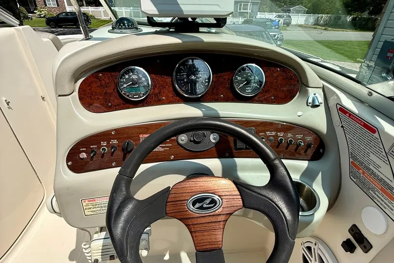 Slide: The Image of 2005 Sea Ray 270 Sundeck dashboard with wood accents and steering wheel. - 6
